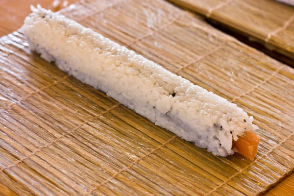 Przygotowaniu japoński rolek z łososia. Bułki na drewniane boa — Zdjęcie stockowe