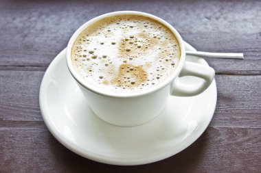 Sütlü köpük ve beyaz porselen cu kabarcıkları ile kahve latte