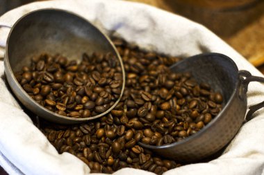 Kahve çekirdekleri bir çuval bezi üzerinde emmek. Gümüş kahve pot ve bardak