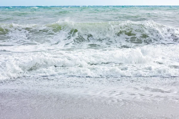 Marea furtunoasa si cerul albastru, spuma alba de mare pe o plaja galbena cu nisip . — Fotografie, imagine de stoc