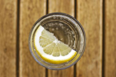 Bir br üzerinde kabarcıklar ile bir bardak limonlu maden suyu gazlı