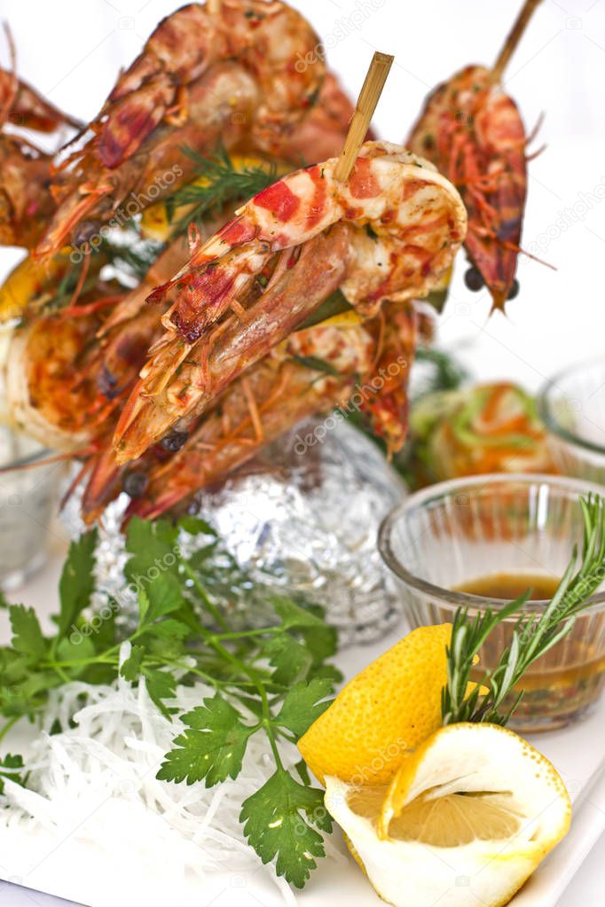 King prawns cooked on wooden skewers. Serving with sauces and he