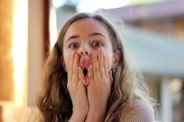 Jovem adolescente menina brincando e fazendo caras engraçadas — Fotografia de Stock