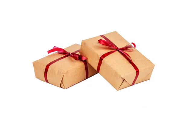 Confezioni regalo in carta da imballaggio artigianale con nastri rossi isolati — Foto Stock