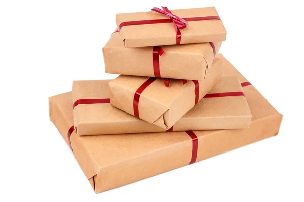 Pilha de caixas de presente em papel de embrulho artesanal com fitas vermelhas isoladas — Fotografia de Stock
