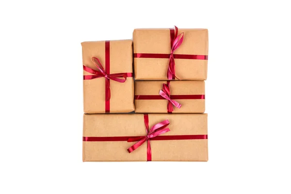 Cajas de regalo en papel de embalaje artesanal con cintas rojas aisladas —  Fotos de Stock