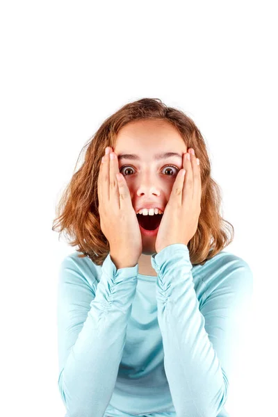 Carino ragazza sta cercando sorpreso e divertente. L'adolescente le mette le mani sulle guance. Felice tween, isolato — Foto Stock