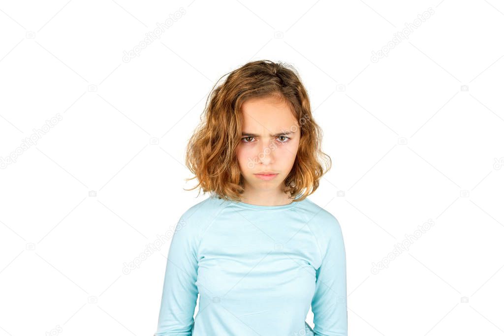 Angry teenager. Beautiful young girl with curly hair angrily looks at the camera