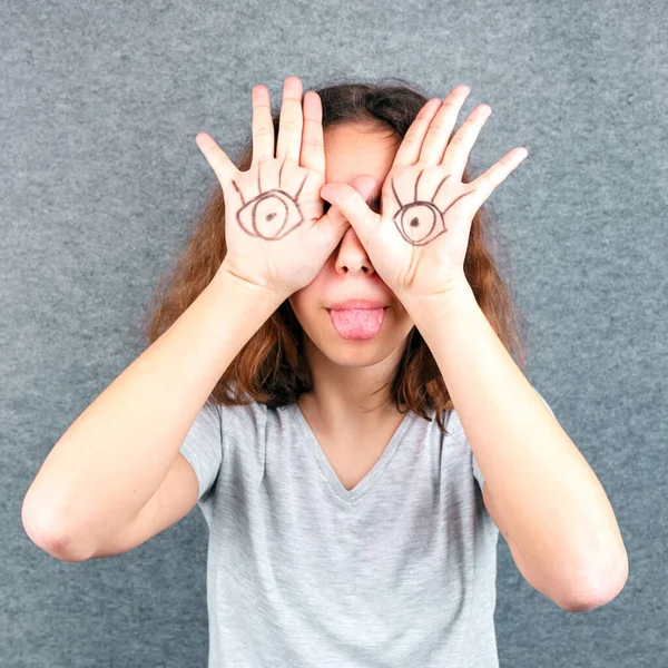 Funny girl with eyes drawn on her palms. April Fools joke
