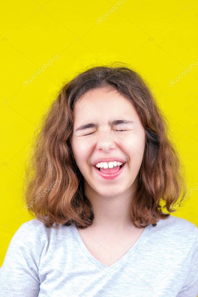 Cute curly teenager girl with a funny face.
