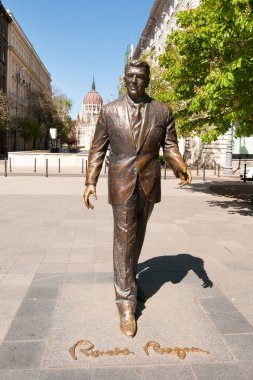 BUDAPEST, HUNGARY - 20 Nisan 2020: Macaristan Parlamento Binası 'nın arka planında eski ABD Başkanı Ronald Reagan' ın heykeli