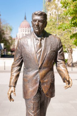 BUDAPEST, HUNGARY - 20 Nisan 2020: Macaristan Parlamento Binası 'nın arka planında eski ABD Başkanı Ronald Reagan' ın heykeli