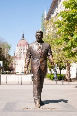 BUDAPEST, HUNGARY - 20 Nisan 2020: Macaristan Parlamento Binası 'nın arka planında eski ABD Başkanı Ronald Reagan' ın heykeli