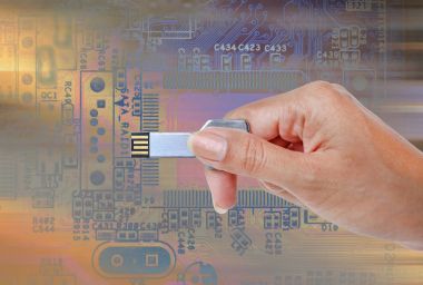 Parlak bir ışık ve devre karşı USB veri depolama tutan el