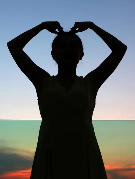 Silhueta da expressão da mulher Forma do coração ao pôr do sol — Fotografia de Stock