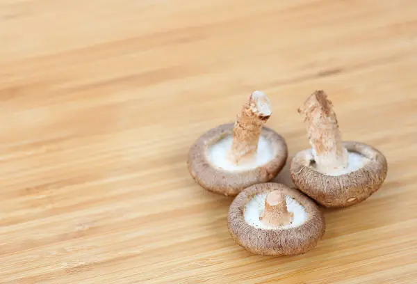 Cogumelo shiitake no fundo de madeira — Fotografia de Stock