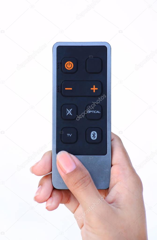 Hand holding remote control on white
