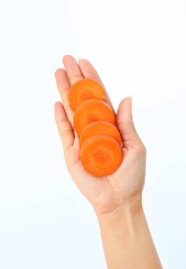 Kadın eli beyaz zemin üzerine havuç dilim