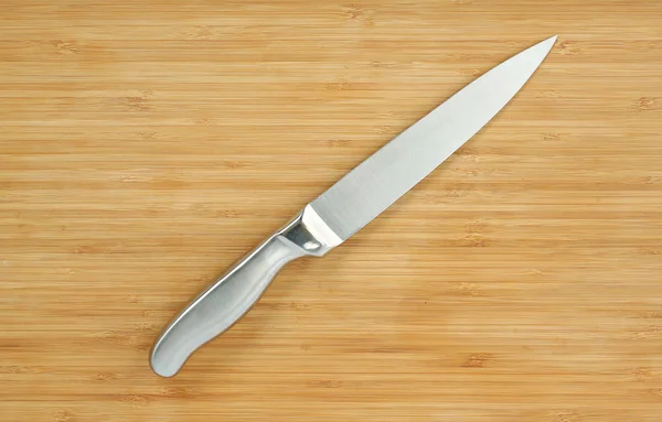 Couteaux de cuisine en acier sur une planche de bois — Photo