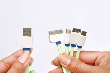 Hands holding many type adapter in 1 USB Charger on white background. universal Charger clipart