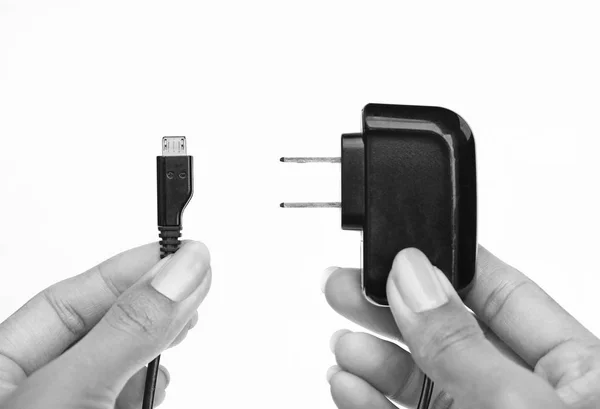 Sujetador de mano Enchufe eléctrico y cable micro usb sobre fondo blanco — Foto de Stock