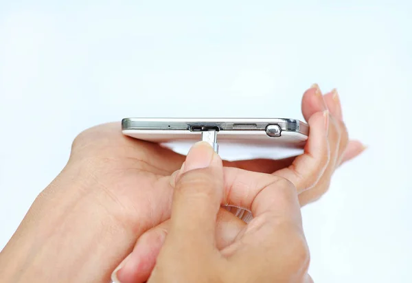 Primer plano de las manos de la mujer conecta el enchufe del cargador de teléfono móvil o teléfono inteligente de carga sobre fondo blanco — Foto de Stock
