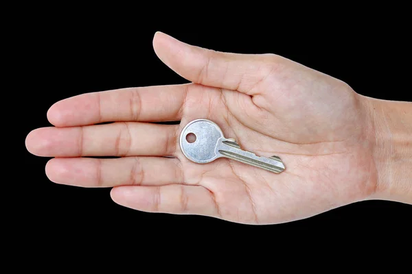 Llave en mano de mujer aislada sobre fondo negro — Foto de Stock