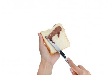 Ekmek ve beyaz arka plan üzerinde kahvaltı yapma çikolatalı reçel tutan el