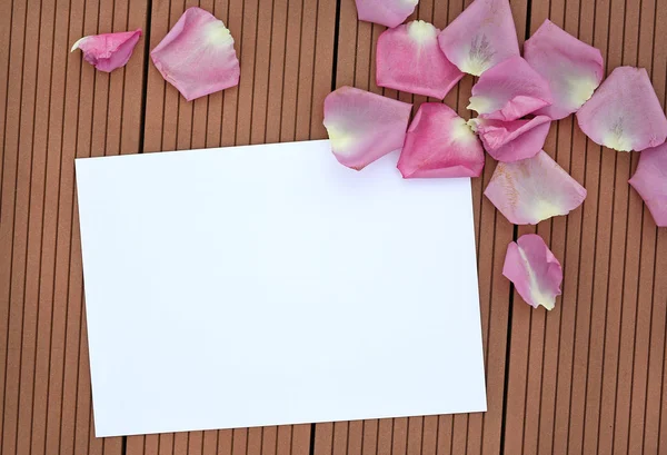 玫瑰花瓣上木制背景空空白卡. — 图库照片
