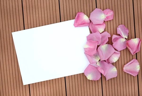 Lege lege kaart met Rose petal op houten achtergrond. — Stockfoto