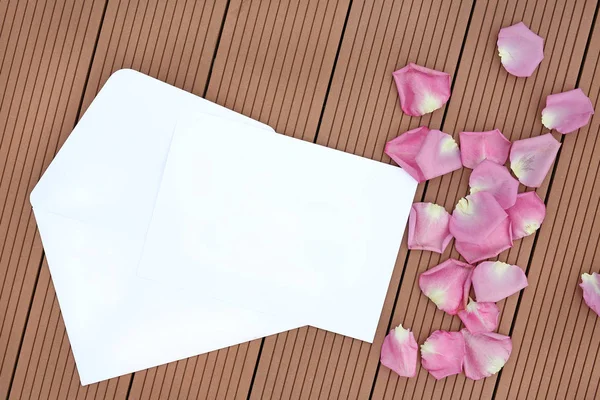 木製の背景にバラの花びらと空の空カード. — ストック写真