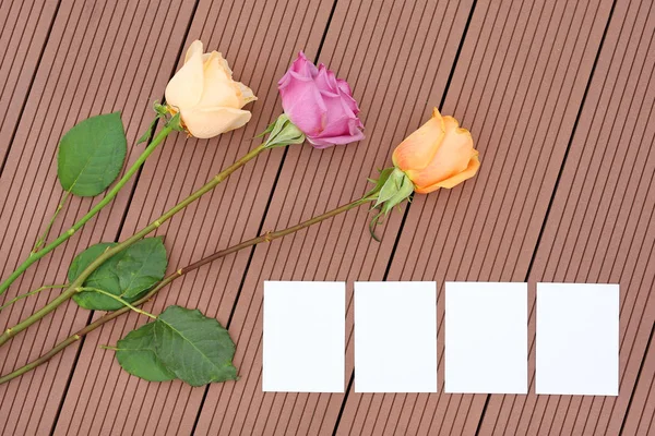 Empty notepaper with rose flower on wooden.