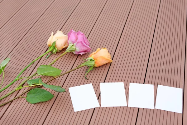 Caderno vazio com flor de rosa em madeira . — Fotografia de Stock