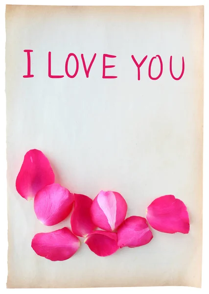 Анотація пелюсток троянд на старому коричневому папері зі словом "Я люблю тебе" ізольовано на білому тлі — стокове фото