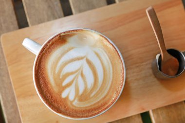 Üstten Görünüm sıcak latte kahve kupa desen ve ahşap masa şurubu