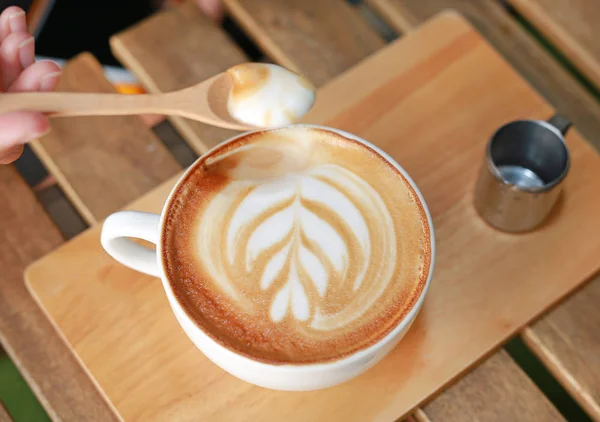 Café con leche caliente vista superior con patrón de corazones y jarabe en mesa de madera — Foto de Stock