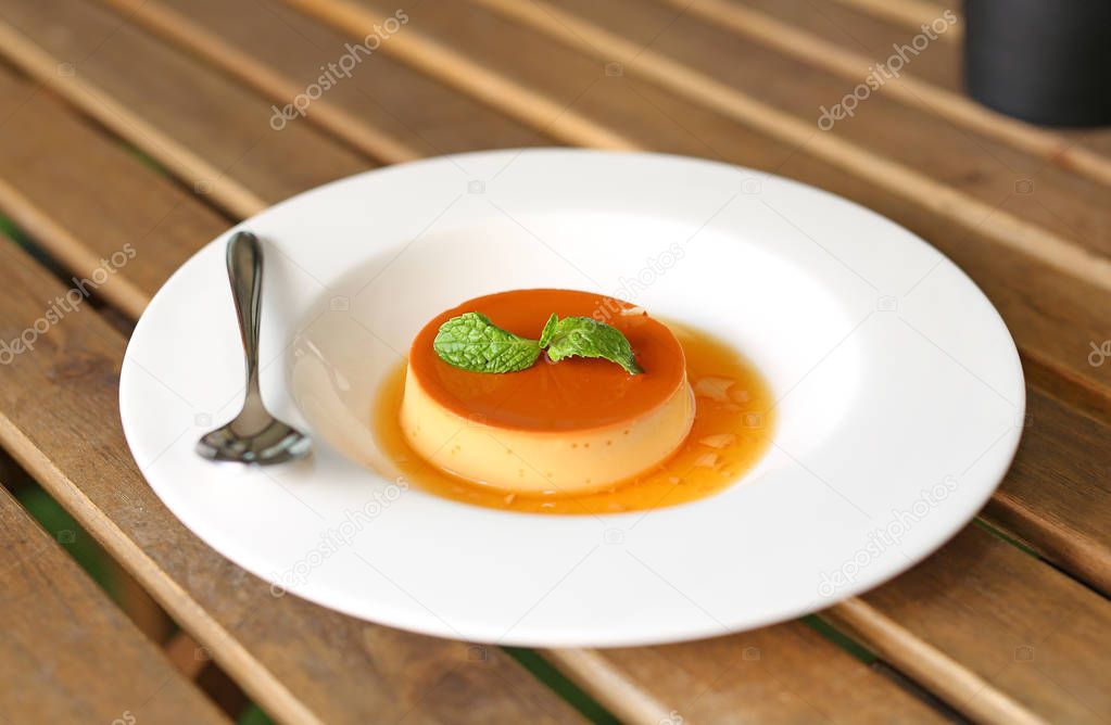 Caramel custard cake with peppermint leaf in white plate.