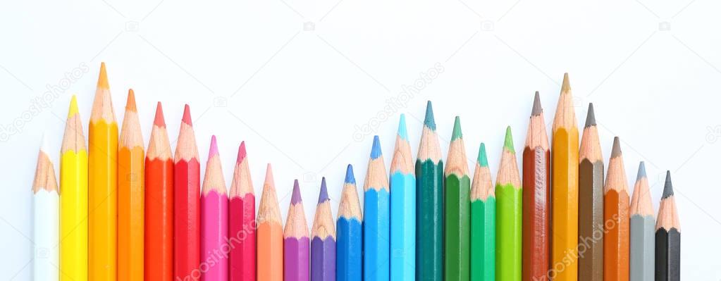 colored pencils row with wave on white background