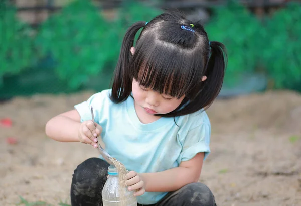 Ładna dziewczynka grając w ogrodzie z gleby — Zdjęcie stockowe