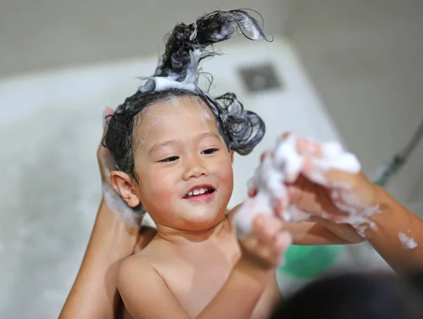 Милая маленькая девочка купается и вымывается своей матерью — стоковое фото