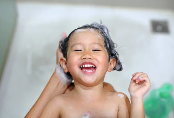 Mignonne petite fille est baigné et shampooing par sa mère — Photo