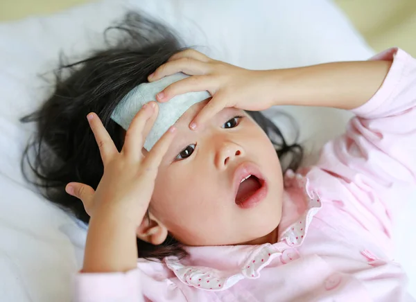 Beteg lány az ágyon egy hideg Vilmos, a fején. — Stock Fotó