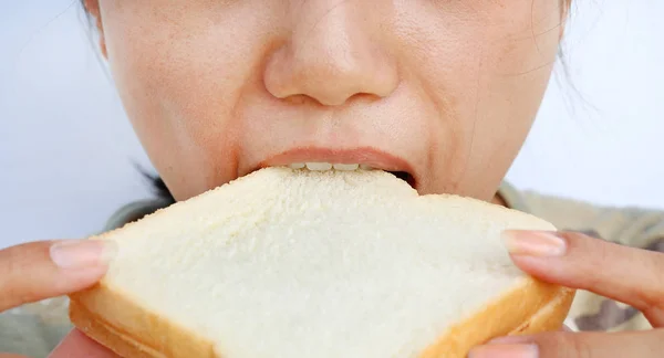 Detailní záběr mladá žena jíst chleba. — Stock fotografie