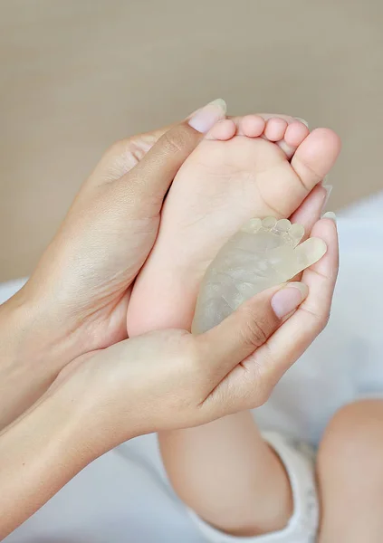 Mãe comparar pé do bebê com pé formando por resina no recém-nascido . — Fotografia de Stock