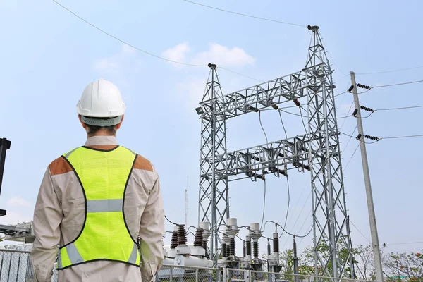 Achteraanzicht van mannelijke bouwvakker tegen de achtergrond van de elektriciteitscentrale — Stockfoto