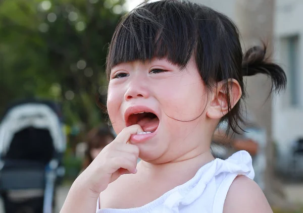 Yakın çekim sevimli küçük kız parkta ağlıyor.