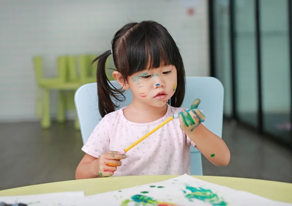 Mignon asiatique enfant fille peinture avec pinceau et aquarelle . — Photo