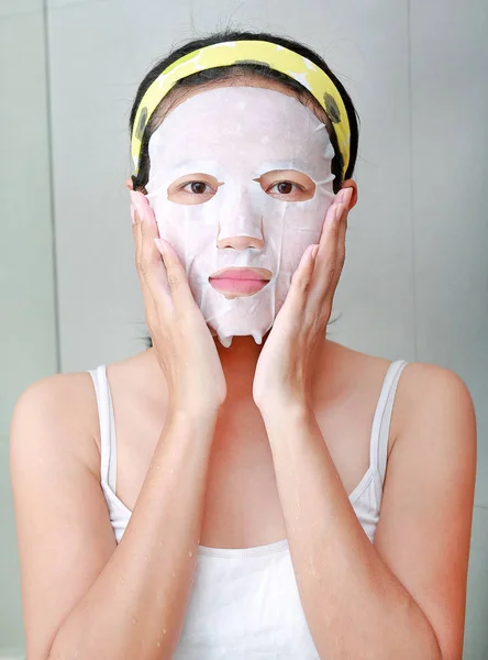 Ritratto di bella giovane donna che applica la maschera facciale di ringiovanimento sul suo viso — Foto Stock