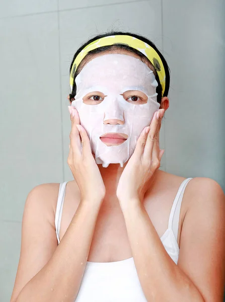 Retrato de bela jovem aplicando máscara facial rejuvenescimento em seu rosto — Fotografia de Stock