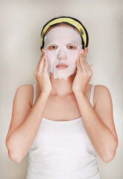 Porträt einer schönen jungen Frau, die eine Gesichtsmaske zur Verjüngung ihres Gesichts aufträgt — Stockfoto